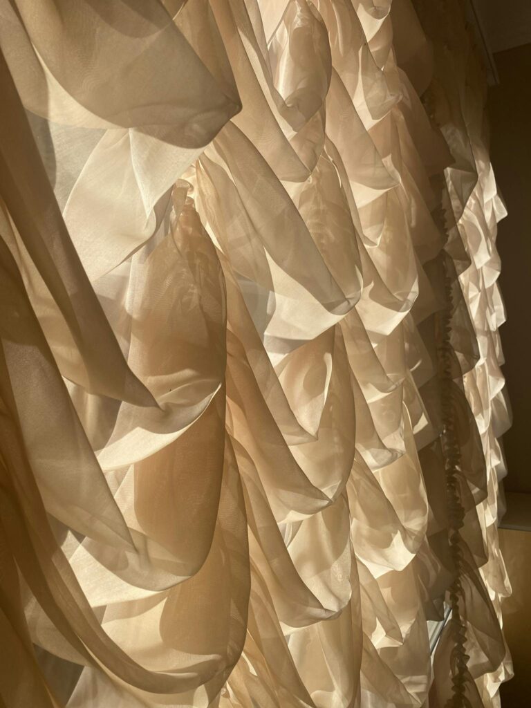 Close-up of elegant tulle curtains softly lit by natural sunlight, creating a dramatic decor effect.