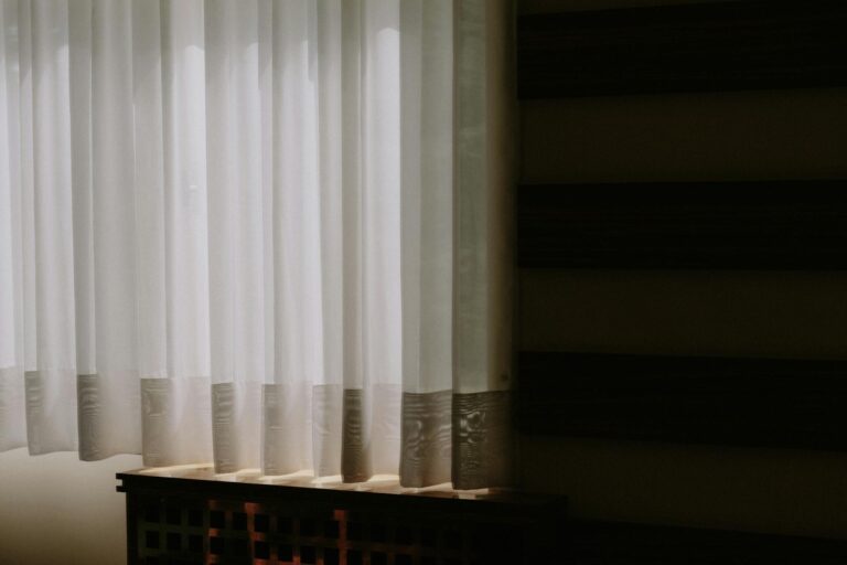 Sheer white curtains allow soft light to filter into a luxurious modern room interior.